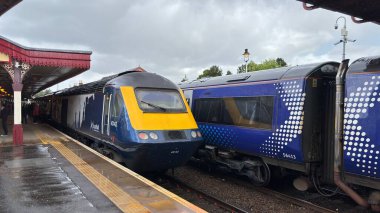 Aviemore tren istasyonu, bir yük treni ve buharlı bir lokomotifle modern seyahatle İskoçya 'nın tarihi cazibesini harmanlıyor..