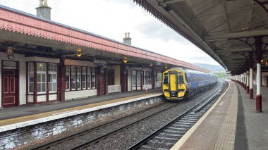 Aviemore tren istasyonu, bir yük treni ve buharlı bir lokomotifle modern seyahatle İskoçya 'nın tarihi cazibesini harmanlıyor..