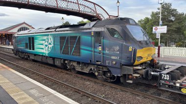 Aviemore tren istasyonu, bir yük treni ve buharlı bir lokomotifle modern seyahatle İskoçya 'nın tarihi cazibesini harmanlıyor..
