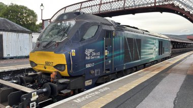 Aviemore tren istasyonu, bir yük treni ve buharlı bir lokomotifle modern seyahatle İskoçya 'nın tarihi cazibesini harmanlıyor..