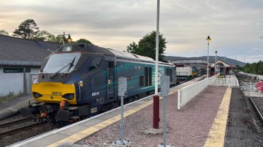 Aviemore tren istasyonu, bir yük treni ve buharlı bir lokomotifle modern seyahatle İskoçya 'nın tarihi cazibesini harmanlıyor..