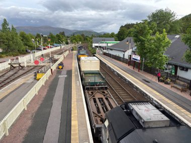 Aviemore tren istasyonu, bir yük treni ve buharlı bir lokomotifle modern seyahatle İskoçya 'nın tarihi cazibesini harmanlıyor..
