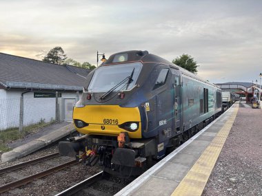 Aviemore tren istasyonu, bir yük treni ve buharlı bir lokomotifle modern seyahatle İskoçya 'nın tarihi cazibesini harmanlıyor..