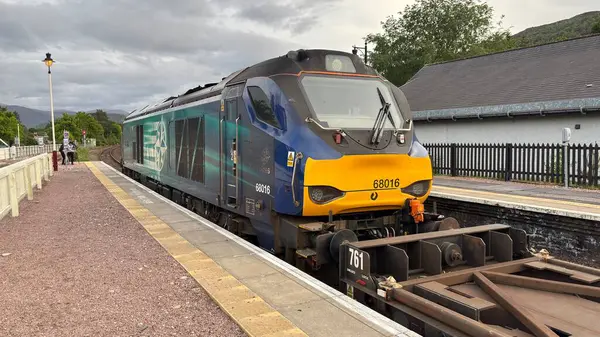 Aviemore tren istasyonu, bir yük treni ve buharlı bir lokomotifle modern seyahatle İskoçya 'nın tarihi cazibesini harmanlıyor..
