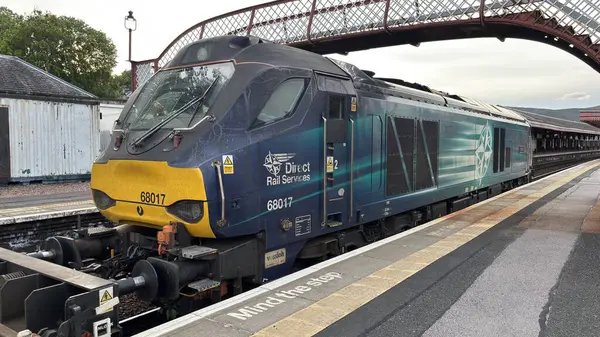 Aviemore tren istasyonu, bir yük treni ve buharlı bir lokomotifle modern seyahatle İskoçya 'nın tarihi cazibesini harmanlıyor..
