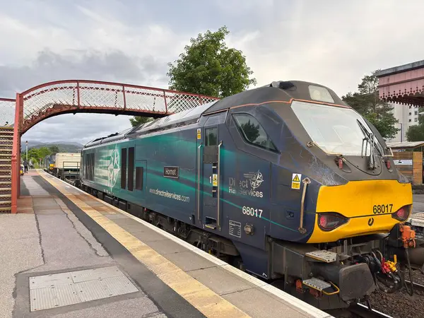 Aviemore tren istasyonu, bir yük treni ve buharlı bir lokomotifle modern seyahatle İskoçya 'nın tarihi cazibesini harmanlıyor..