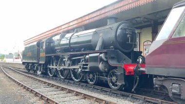 Tarihi bir buhar lokomotifi Aviemore istasyonunu buharla buharlaştırarak nefes kesen Highland manzarasıyla nostaljik cazibeyi harmanlıyor..