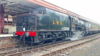 Tarihi bir buhar lokomotifi Aviemore istasyonunu buharla buharlaştırarak nefes kesen Highland manzarasıyla nostaljik cazibeyi harmanlıyor..