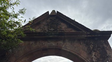 Cranshaws Kalesi 'nin giriş kapısı 19. caddenin sonundaki kırmızı kumtaşı kemeri demir kapılı, ibikli ve mineralli tarihi kabuklu kuleye bir göz atmak için..