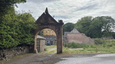 Cranshaws Kalesi 'nin giriş kapısı 19. caddenin sonundaki kırmızı kumtaşı kemeri demir kapılı, ibikli ve mineralli tarihi kabuklu kuleye bir göz atmak için..