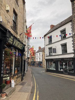 Eski manastır ve ortaçağ sokaklarının sonbahar ışığında yıkandığı tarihi Hexham market sahnesi.