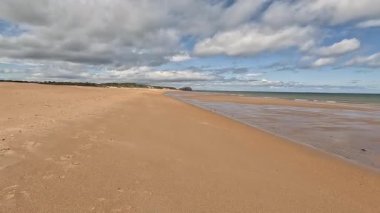 Doğu Lothian 'daki Ravensheugh Kumsalı' nda yürümek kumlu kıyıları, yumuşak dalgaları ve yaz gökyüzünün altındaki kıyı manzarasını gözler önüne sermek.