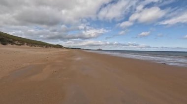 Doğu Lothian 'daki Ravensheugh Kumsalı' nda yürümek kumlu kıyıları, yumuşak dalgaları ve yaz gökyüzünün altındaki kıyı manzarasını gözler önüne sermek.