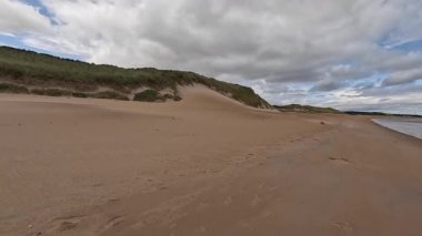 Doğu Lothian 'daki Ravensheugh Kumsalı' nda yürümek kumlu kıyıları, yumuşak dalgaları ve yaz gökyüzünün altındaki kıyı manzarasını gözler önüne sermek.