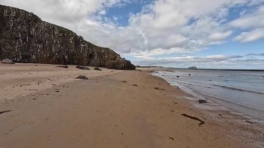 Doğu Lothian 'daki Ravensheugh Kumsalı' nda yürümek kumlu kıyıları, yumuşak dalgaları ve yaz gökyüzünün altındaki kıyı manzarasını gözler önüne sermek..