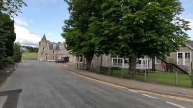 Viktorya dönemi Nethybridge Oteli 'nin dış yüzeyi. Kule bloğu, peyzaj bahçesi ve Cairngorm arkaplanı var..