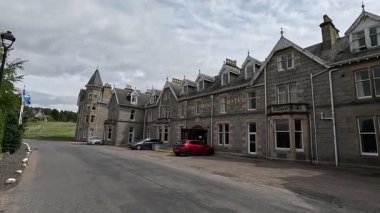 Viktorya dönemi Nethybridge Oteli 'nin dış yüzeyi. Kule bloğu, peyzaj bahçesi ve Cairngorm arkaplanı var..