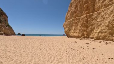 Praia da Rocha 'daki Atlantik Sahili' nde altın kumu, geniş kıyı şeridi, uçurum arkası, berrak deniz ve canlı bir sahil ortamı var. Portimao, Portekiz. Portimo