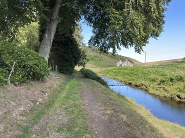 Boyalı Su, kıyılarına kurulmuş tarihi Dunside Kır Evi 'ni nazikçe geçiyor. Ormanlık tepeler, yuvarlanan yamaçlar ve sakin İskoç kırsalları tarafından çerçeveleniyor..