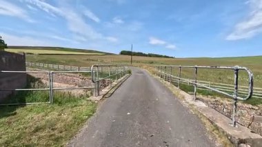 İskoç sınırlarındaki Su Barajı 'nın yanında yürüyüp sakin suları, mühendislik yapılarını ve berrak gökyüzünün altındaki sakin bozkır manzaralarını yakalıyor..