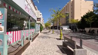 Portimo şehir merkezinde gezen sokak manzaraları, tarihi sessizlikleri, plazaları, kaldırım kafelerini, yaya yollarını ve nehir kıyısındaki kentsel yaşamı gösteriyor.