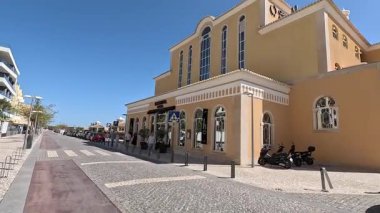 Portimo şehir merkezinde gezen sokak manzaraları, tarihi sessizlikleri, plazaları, kaldırım kafelerini, yaya yollarını ve nehir kıyısındaki kentsel yaşamı gösteriyor.