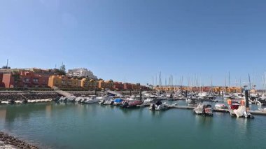 Portimo şehir merkezinde gezen sokak manzaraları, tarihi sessizlikleri, plazaları, kaldırım kafelerini, yaya yollarını ve nehir kıyısındaki kentsel yaşamı gösteriyor.