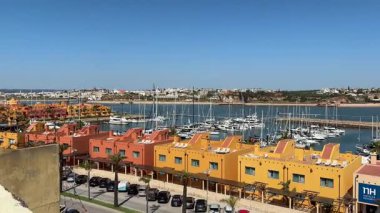 Portimo şehir merkezinde gezen sokak manzaraları, tarihi sessizlikleri, plazaları, kaldırım kafelerini, yaya yollarını ve nehir kıyısındaki kentsel yaşamı gösteriyor.