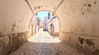 Portimo şehir merkezinde gezen sokak manzaraları, tarihi sessizlikleri, plazaları, kaldırım kafelerini, yaya yollarını ve nehir kıyısındaki kentsel yaşamı gösteriyor.