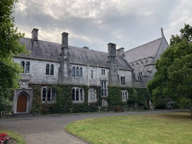 Cork şehir merkezindeki University College Cork kampüsünün dış görüntülerinde, gün ışığı altında tarihi akademik binalar yer alıyor.