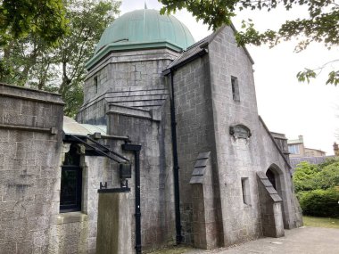 Cork şehir merkezindeki University College Cork kampüsünün dış görüntülerinde, gün ışığı altında tarihi akademik binalar yer alıyor.