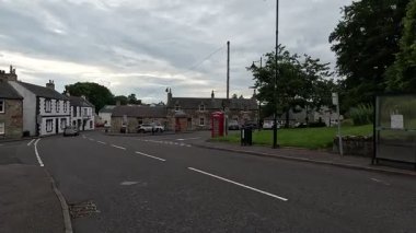 Batı Lothian, Torphichen 'deki geleneksel köy binaları tarihi taş mimarisini ve yaz gökyüzünün altında huzurlu kırsal sokakları sergiliyor..