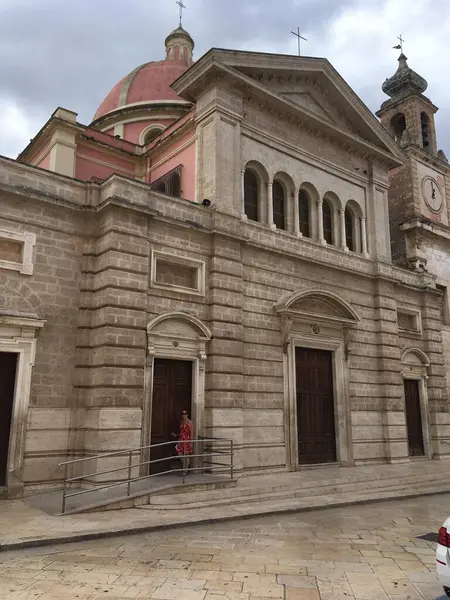 Fisano 'nun caddeleri, binaları ve anıtlarıyla canlı bir şehirde İtalyan mimarisi ve yerel kültürü sergileyen manzarası.