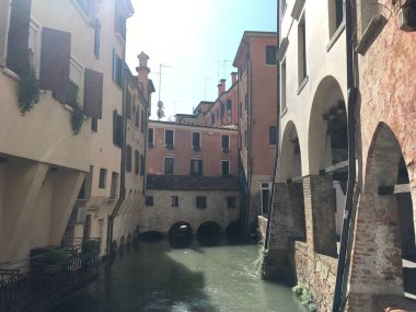 Gündüz vakti kanalların, köprülerin ve geleneksel mimarinin yer aldığı Treviso şehir caddelerinin ve tarihi binaların manzarası. İtalya