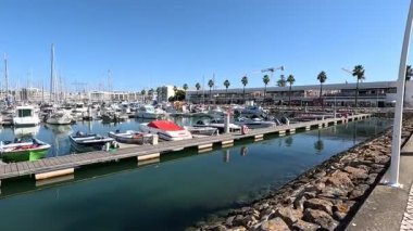Portekiz: Lagos limanı canlı marina, gezinti güvertesi, sakin sular ve kıyı atmosferiyle demirlenmiş tekneler