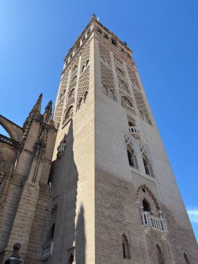 İspanya: Sıcak ışık altında Seville caddesi mimarisi, tarihi cephelerin, dar sokakların, balkonların ve süs eşyalarının sergilendiği.