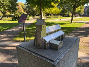 Remains of Gamla kyrkans grund former Saint John the Baptist church in Landskrona Sweden town park featuring exposed stone bases brick remnants and central wooden cross for summer services.