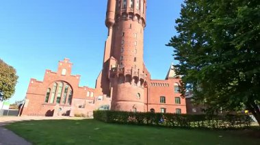 Gamla Vattentornet 1904 water tower exterior in Landskrona Sweden featuring cylindrical brick structure and reservoir tank now residential building with Oresund sea views.
