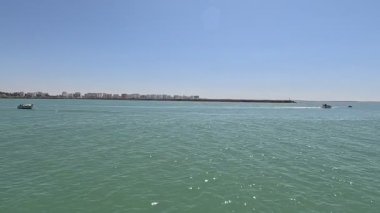 Bay of Cadiz catamaran ferry service in Spain connecting Cadiz port to El Puerto de Santa Maria and Rota featuring onboard deck perspectives harbor skyline and expansive Atlantic sea passages.