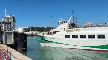 Bay of Cadiz catamaran ferry service in Spain connecting Cadiz port to El Puerto de Santa Maria and Rota featuring onboard deck perspectives harbor skyline and expansive Atlantic sea passages.