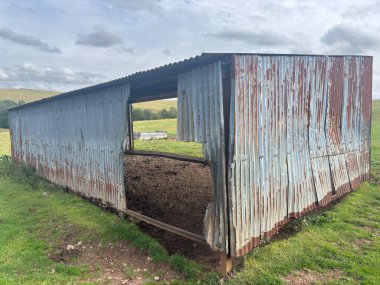 İskoç sınırlarındaki sığırlar için harap olmuş metal ahır yıpranmış demir levhalar, sarkık çelik yapılar, enkaz yığınları, bitişik taş duvarlar, koyun tarlaları ve bulutlu gökyüzü altındaki uzak bozkırlar..