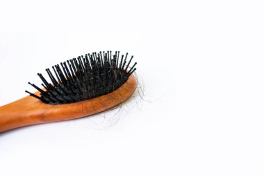 Saçlar beyaz arka planda, saçlar tarakta dökülüyor..