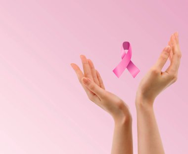 Göğüs kanseri farkındalığı, pembe kurdele, pembe kurdeleli eller, sağlık kontrolü, kontrol, steteskop. Pembe kurdele tutan kadın elleri