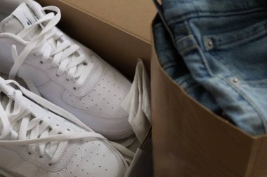 Bir kutuda yeni bir çift beyaz spor ayakkabı ve kotları kese kağıdında katlanmış. Yüksek kalite fotoğraf