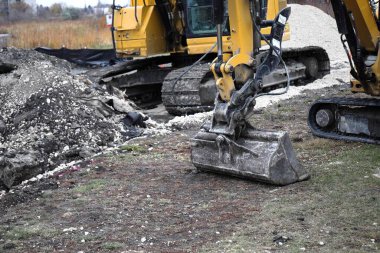 Sarı kazıcılar şehir binalarının zeminine karşı bir inşaat alanında çalışıyorlar..
