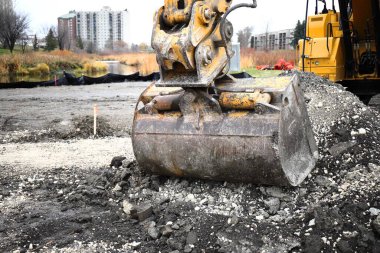 Sarı kazıcılar şehir binalarının zeminine karşı bir inşaat alanında çalışıyorlar..