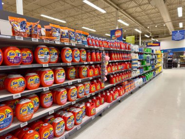 A row of shelves with cleaning products in a store, including Tide and other brands, bright lighting, clean. clipart