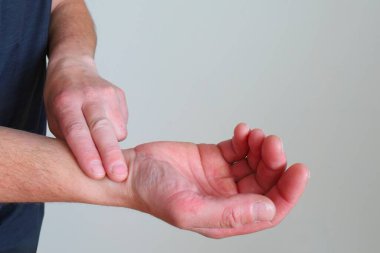 Biri diğerinin bileğindeki iki parmağıyla nabzını hafif bir arkaplanda ölçer..