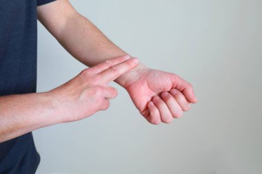 Biri diğerinin bileğindeki iki parmağıyla nabzını hafif bir arkaplanda ölçer..
