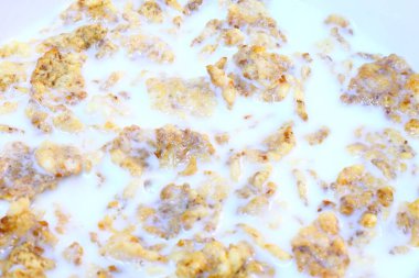 Bir kase sütlü mısır gevreği, bir insan bir kaşık tutuyor..